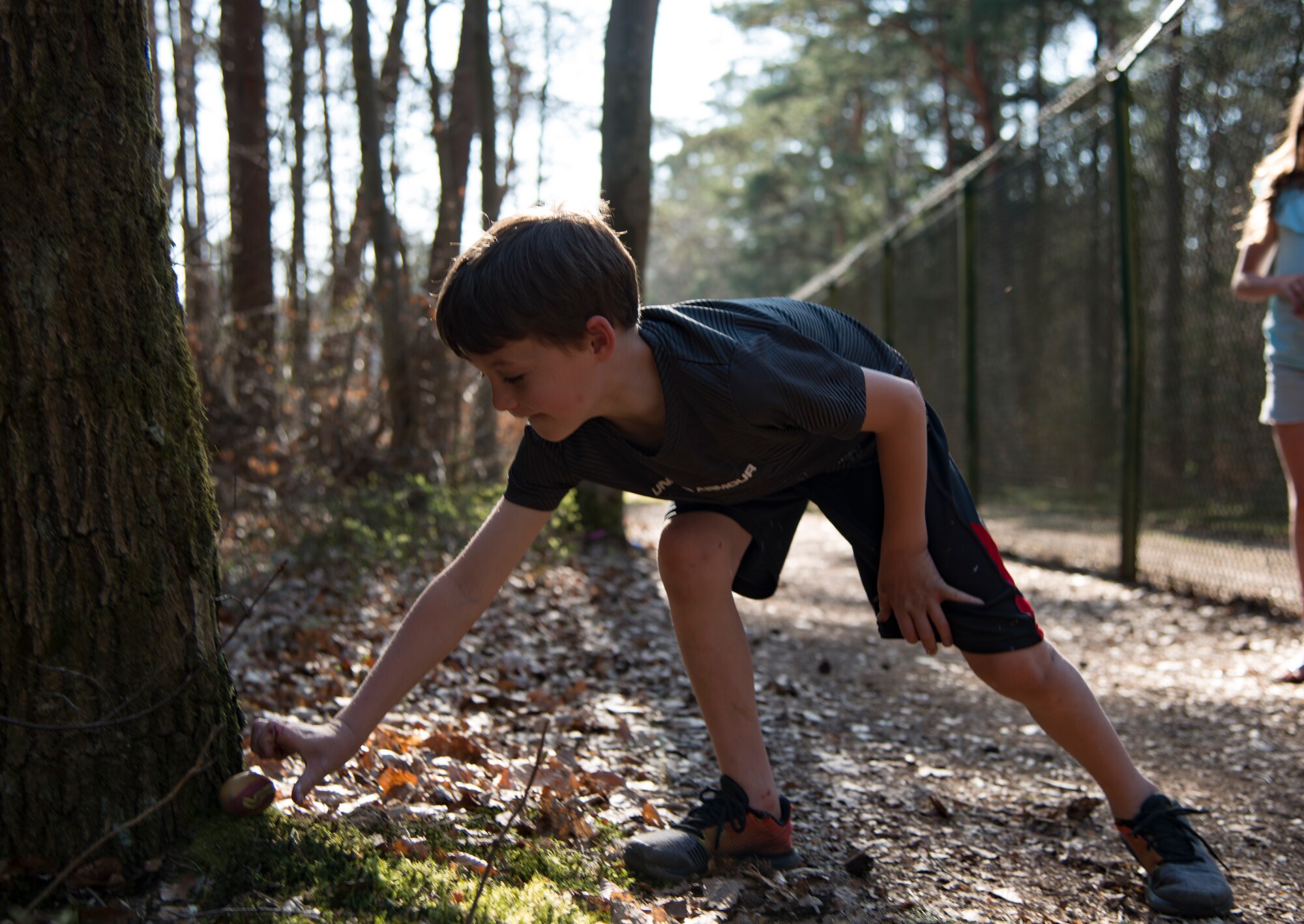 Gavin Gentry, Ramstein Elementary School student, places a painted rock to bring joy to those who find it at Ramstein Air Base, Germany, April 7, 2020.
