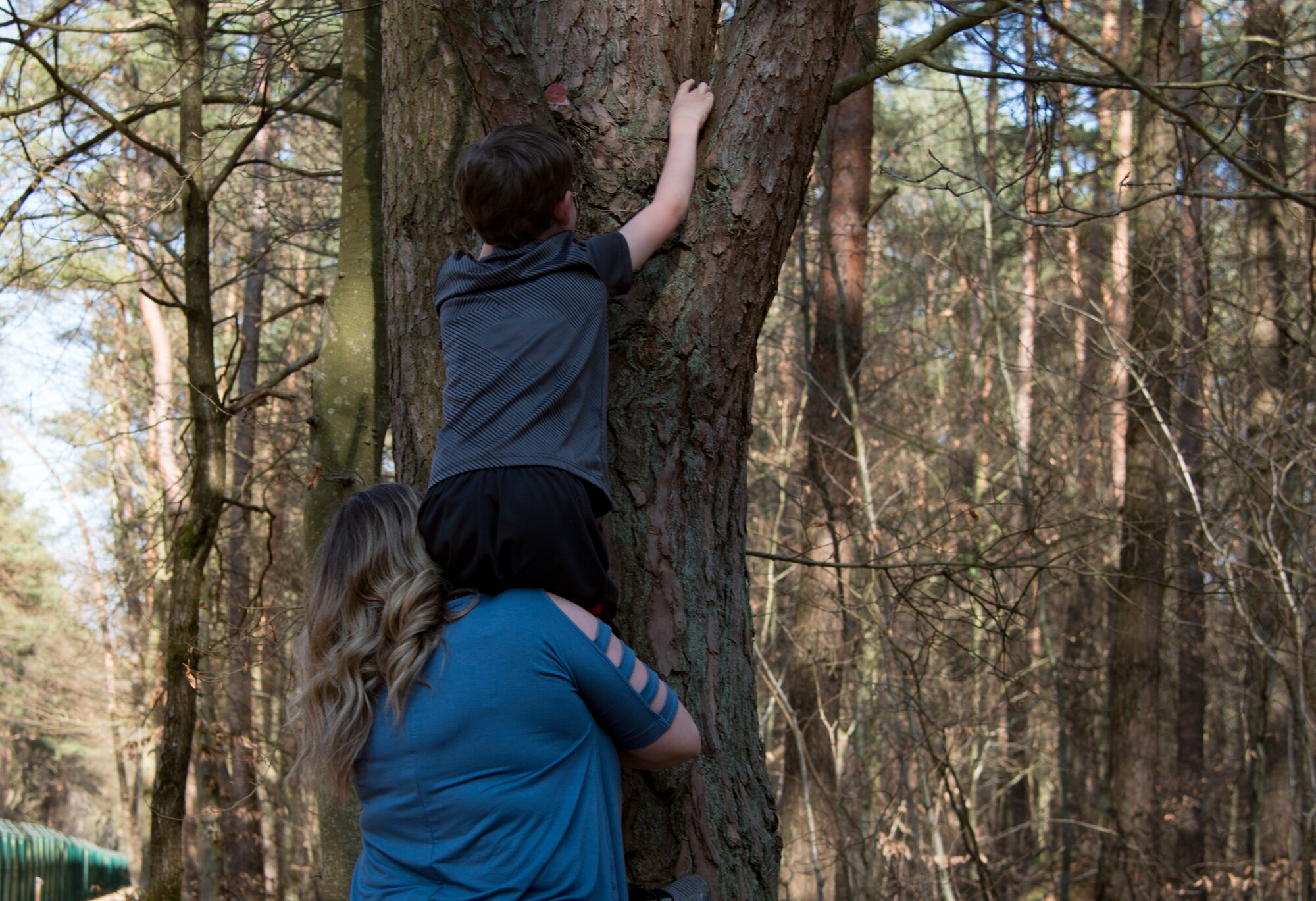 Gavin Gentry, top, Ramstein Elementary School student, places a painted rock while his mother, Danyelle Gentry, Ramstein Elementary School front office assistant, holds him at Ramstein Air Base, Germany, April 7, 2020.