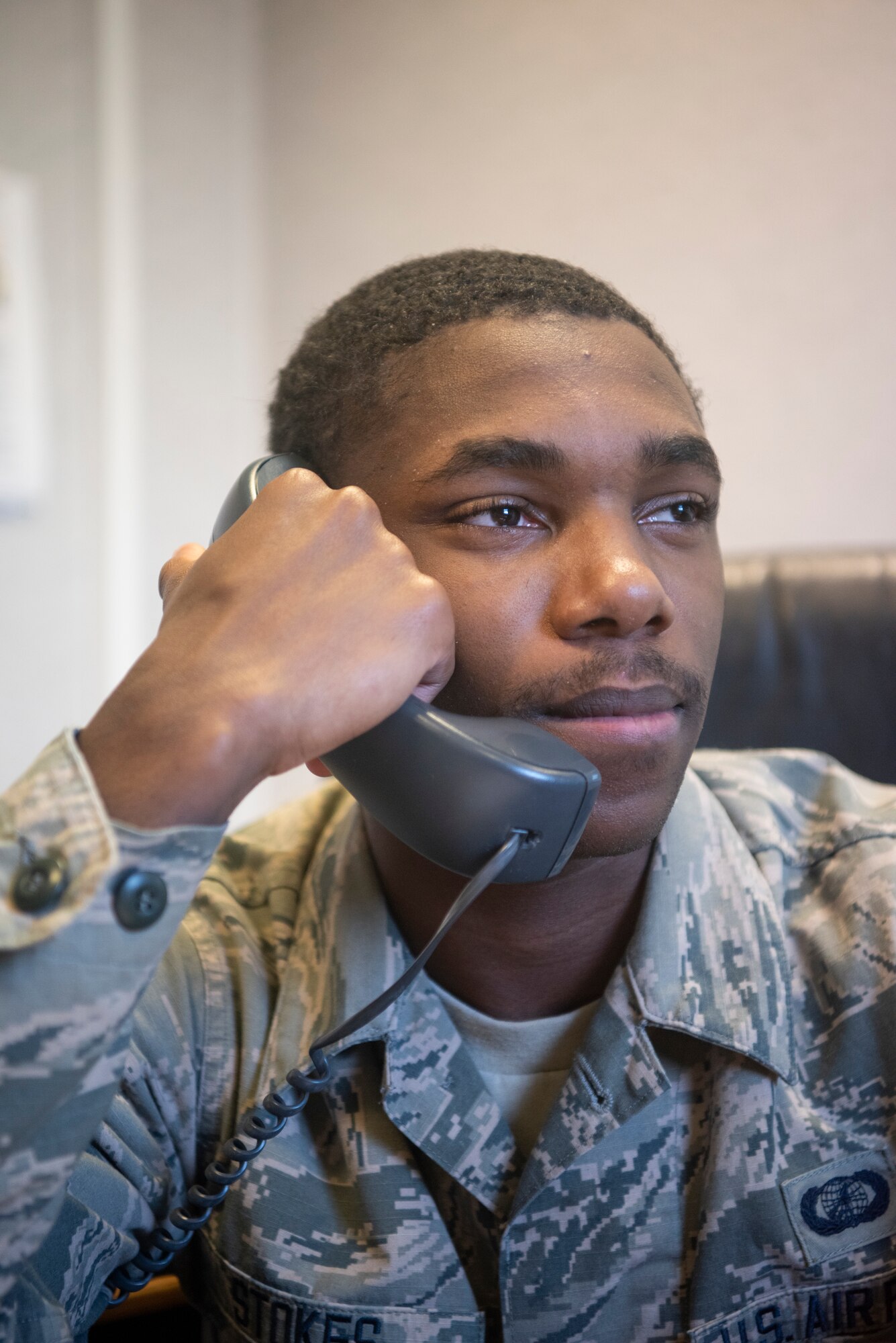 Airman 1st Class Tyran Stokes, 100th Wing Staff Agencies unit control center representative, listens to an agency chief report the quarantine status of an Airman April 8, 2020, at RAF Mildenhall, England. The UCC representatives update the status of military members in quarantine or isolation daily to provide an accurate view to leadership of how the virus is impacting the base. (U.S. Air Force photo by Airman 1st Class Joseph Barron)