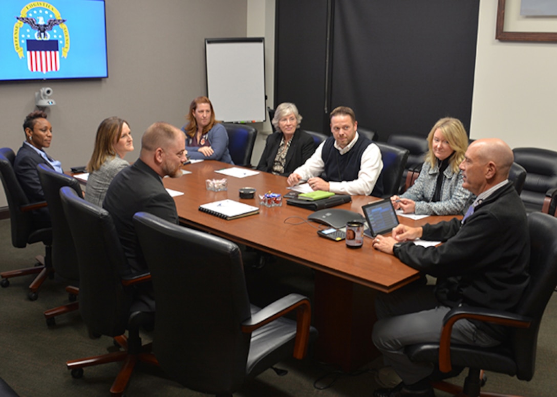 Air Force and Aviation employees talk around conference table