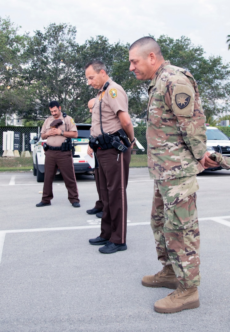 Maj. Jaime Villacorta, chaplain of the 50th Regional Support Group, Florida National Guard, prays with Miami-Dade police at a COVID-19 test site at Hard Rock Stadium, Miami Gardens, Fla., April 5, 2020. Villacorta has provided spiritual support to Soldiers and first responders in South Florida.