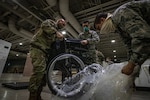 New Jersey Air National Guard Airmen put together wheelchairs during the buildup of a field medical station at the Atlantic City Convention Center in Atlantic City April 9, 2020. Atlantic City is one of three stations that will offer overflow from local hospitals focused on COVID-19 patients.