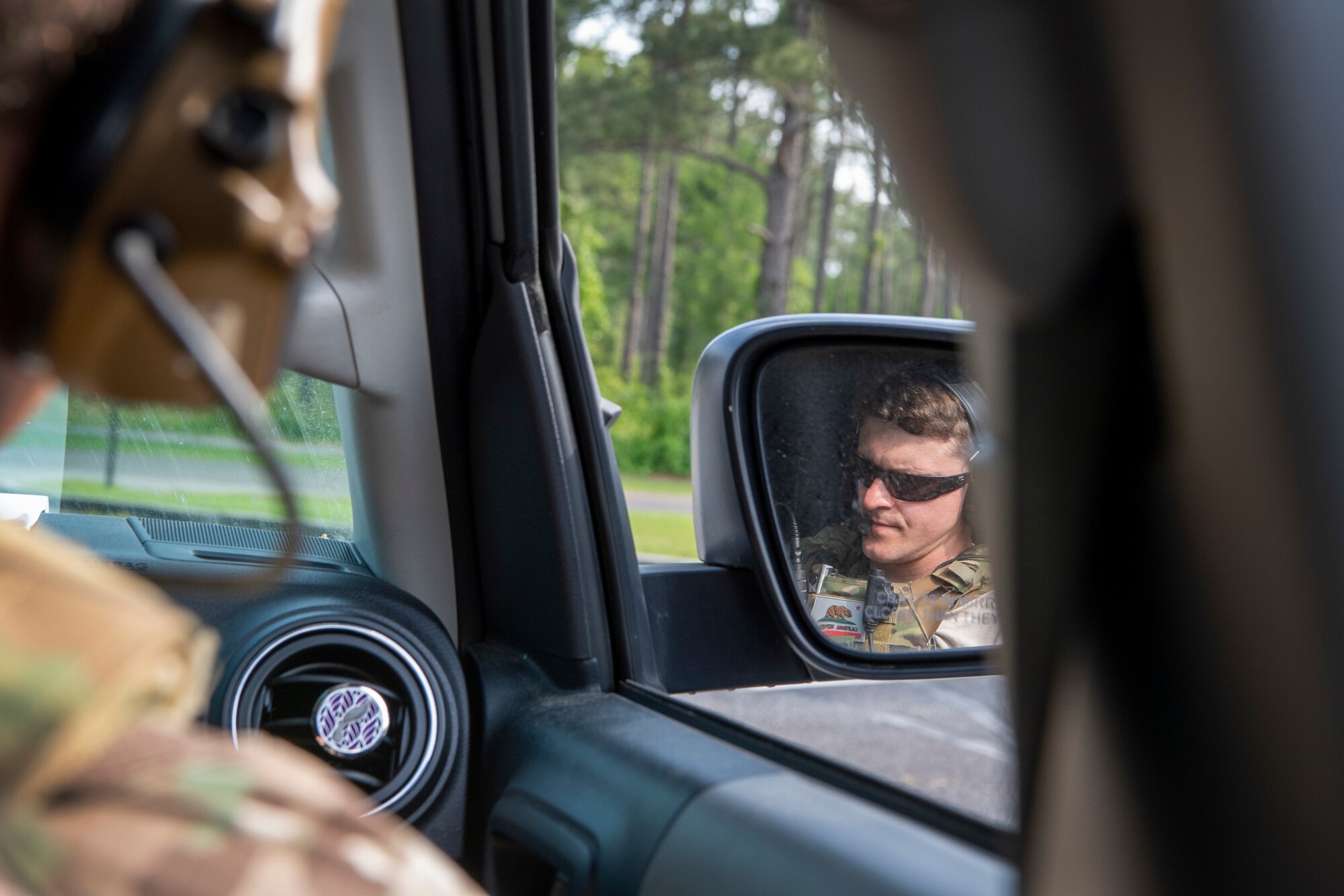 TACP officer talks on a radio in a car