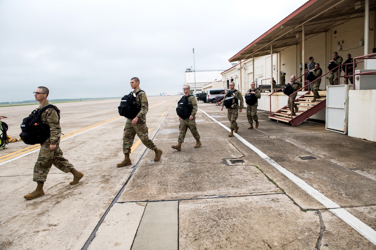 Airmen maintain social distancing as they move in single file.