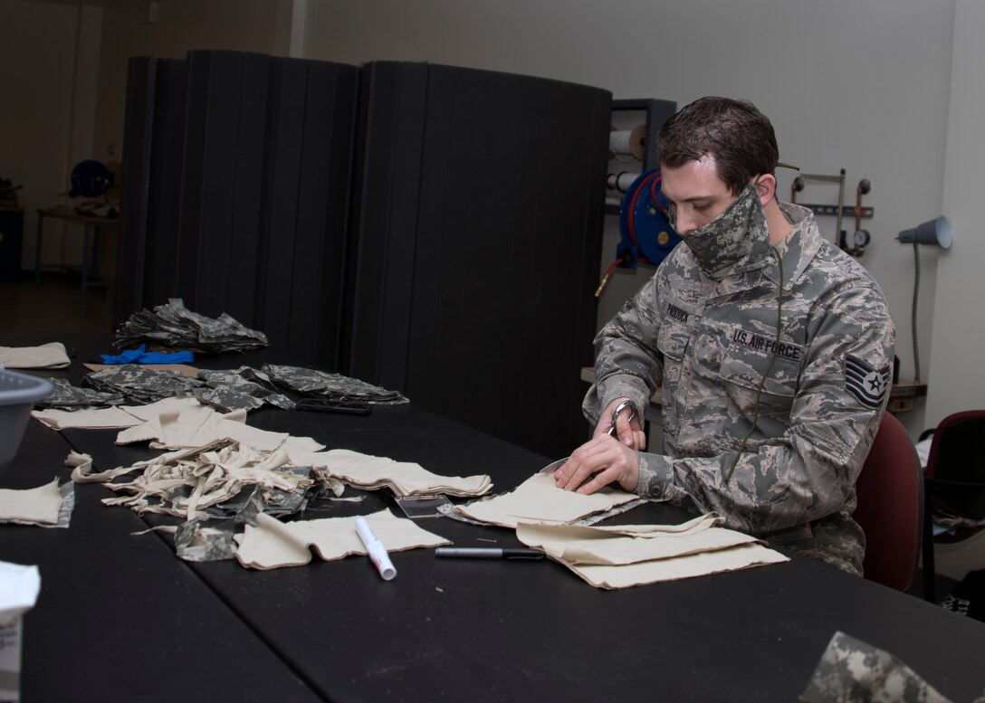 Tech Sgt. Jamey Paddock, 459th Operations Support Squadron, Aircrew Flight Equipment technician, cuts pieces of fabric for an Air Force authorized face mask that will be distributed to air crew members and maintainers and members of the wing during COVID-19, April 10th, 2020 at Joint Base Andrews, Md. Paddock and members of his team volunteered to make the masks and are estimating to make 1,000 in total. (U.S. Air Force photo/Staff Sgt. Cierra Presentado)