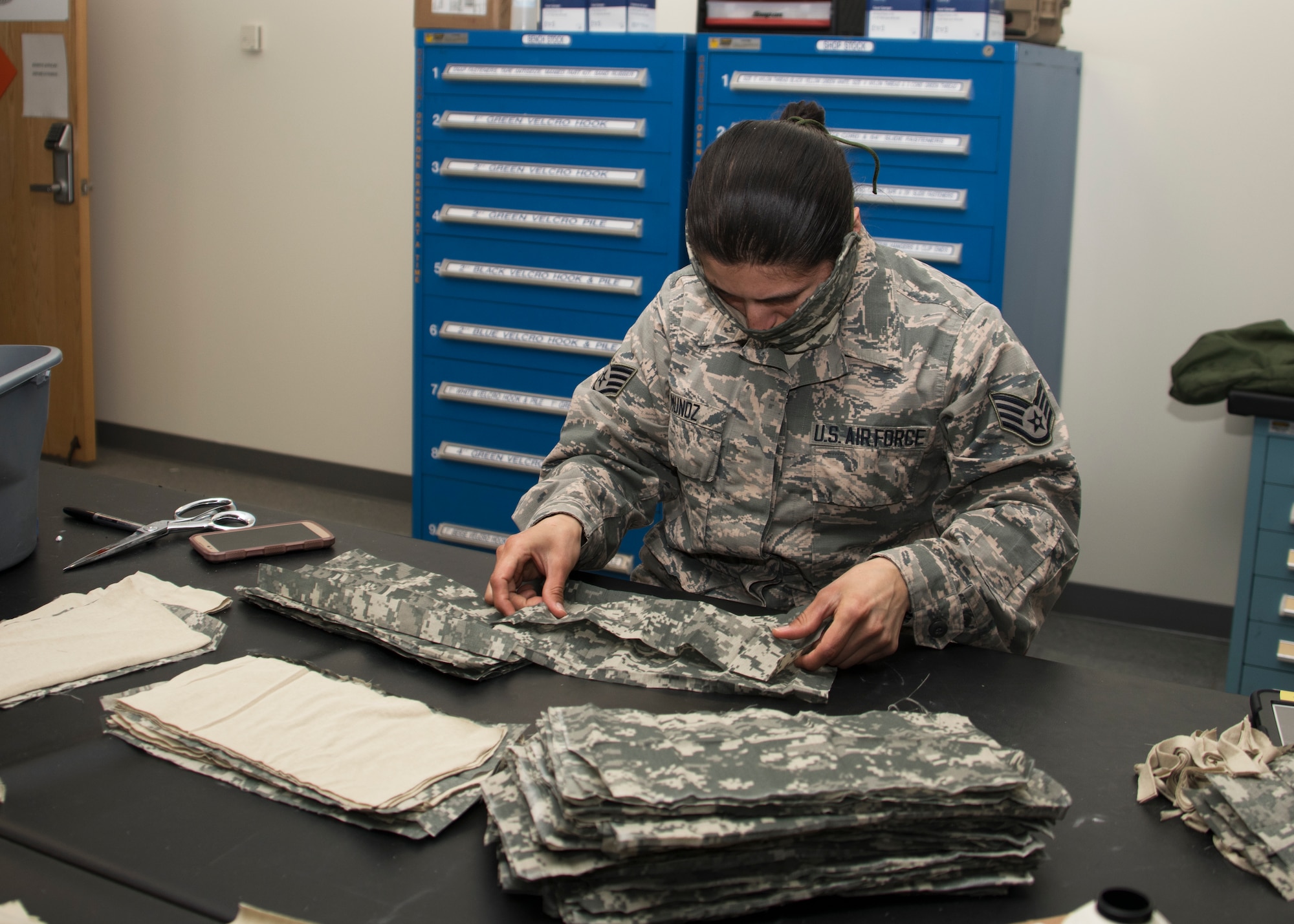 Staff Sgt. Viridiana Munoz, 459th Operations Support Squadron, Aircrew Flight Equipment technician, separates fabric for face masks, April 10th, 2020, at Joint Base Andrews, Md. Munoz and her team are able to make the masks using old uniforms provided by the 459th Logistics Readiness Squadron in addition to supplies from the AFE shop. The team plans to make 1,000 masks to be distributed to aircrew, maintainers and members of the wing. (U.S. Air Force photo/Staff Sgt. Cierra Presentado)
