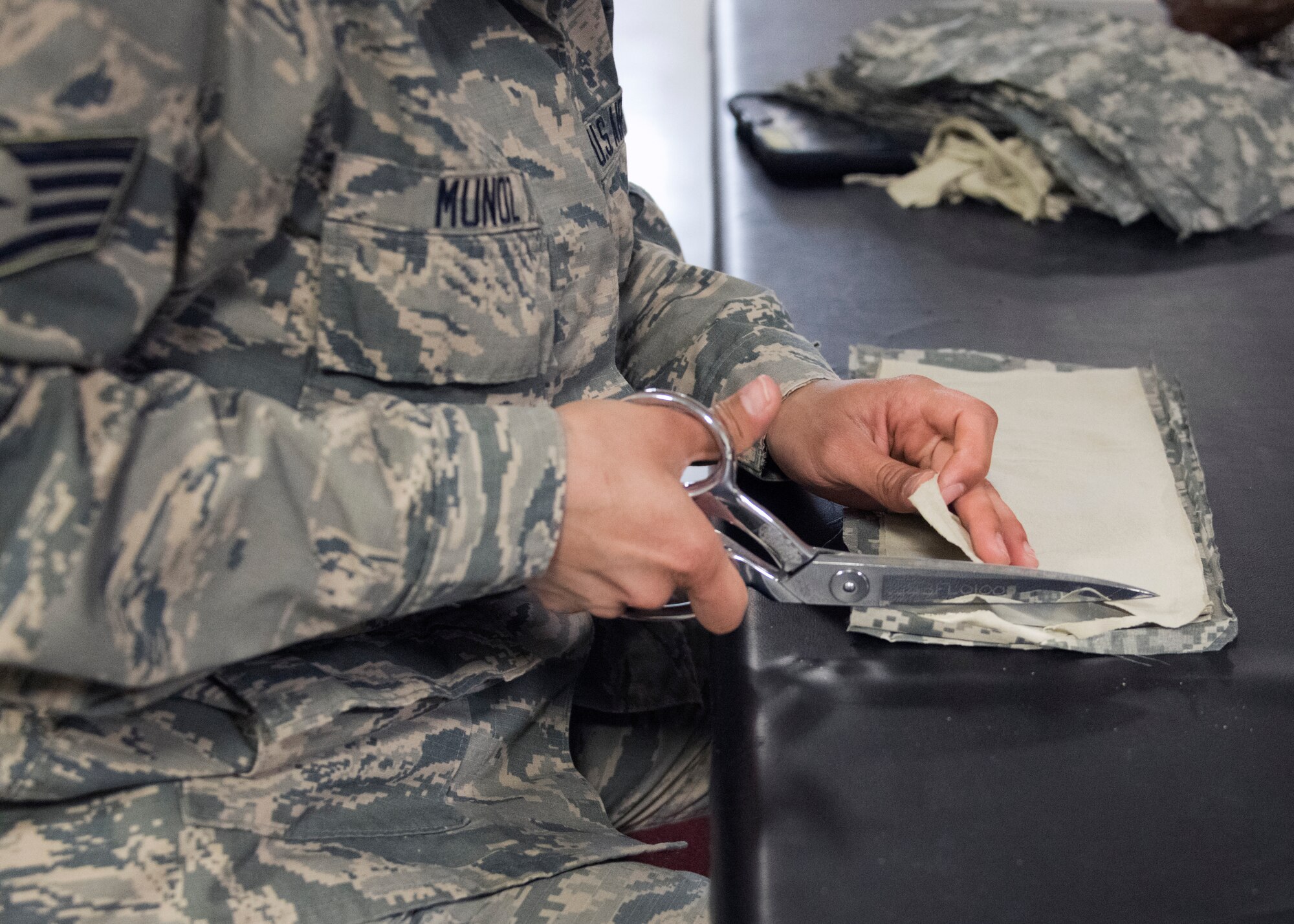 Staff Sgt. Viridiana Munoz, 459th Operations Support Squadron, Aircrew Flight Equipment technician, cuts pieces of fabric donated from the 459th Logistics Readiness Squadron, to make Air Force authorized face masks, April 10th, 2020, at Joint Base Andrews Md. Munoz and her team volunteers to make at least 1,000 face makes for aircrew, maintainers and members of the wing to provide an additional layer of safety as the mission continues through COVID-19. (U.S. Air Force photo/Staff Sgt. Cierra Presentado)
