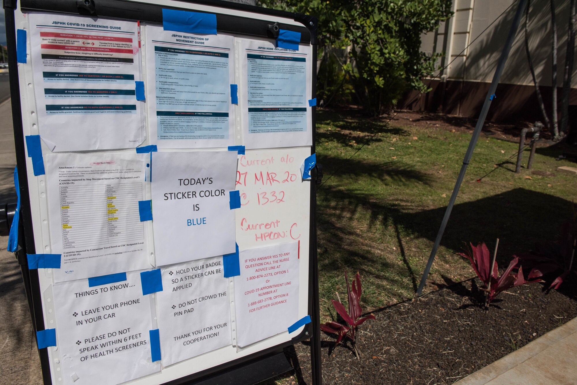 An informational board is set up outside the 613th Air Operations Center on Joint Base Pearl Harbor-Hickam, Hawaii, April 1, 2020. Members assigned to the AOC take new precautionary measures in order to maintain the health and safety of mission essential personnel. These measures include: health screening questions, temperature checks and hand sanitizing. (U.S. Air Force photo by Staff Sgt. Hailey Haux)