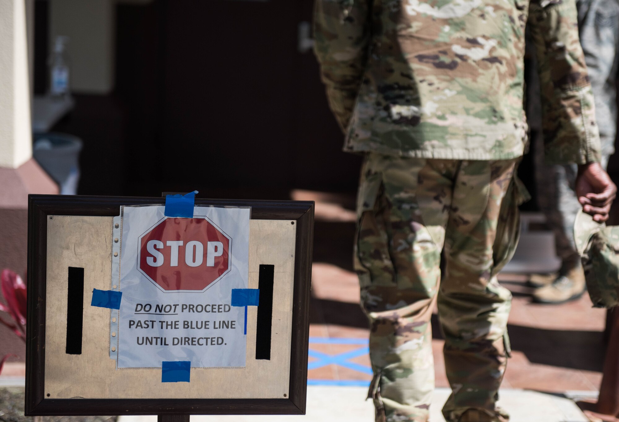 An Airman proceeds to the temperature checkpoint at the 613th Air Operations Center on Joint Base Pearl Harbor-Hickam, Hawaii, April 1, 2020. Members assigned to the AOC take new precautionary measures to maintain the health and safety of mission essential personnel. These measures include: health screening questions, temperature checks and hand sanitizing. (U.S. Air Force photo by Staff Sgt. Hailey Haux)