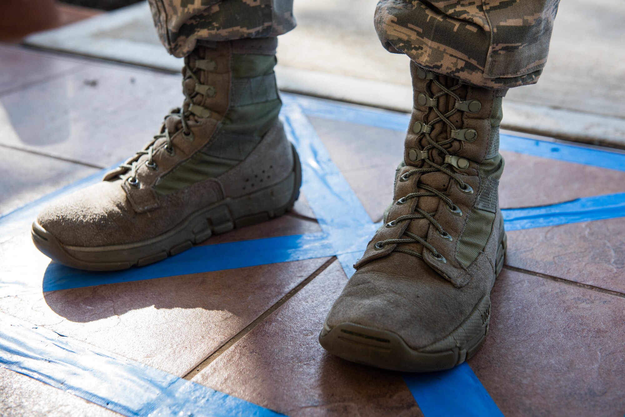 An Airman waits as her temperature is checked as part of a new process for those assigned to the 613th Air Operations Center on Joint Base Pearl Harbor-Hickam, Hawaii, April 1, 2020. There are new precautionary measures set up in order to maintain the health and safety of mission essential personnel. These measures include: health screening questions, temperature checks and hand sanitizing. (U.S. Air Force photo by Staff Sgt. Hailey Haux)