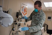 Major Bryan Sixkiller, an optometrist assigned to the 628th Medical Group, Operational Medical Readiness Squadron, cleans equipment at the Optometry Clinic at Joint Base Charleston, S.C., April 7, 2020. Optometry is taking safety measures such as limiting face-to-face time, wearing masks and gloves, frequently washing hands and cleaning medical equipment before and after each examination.