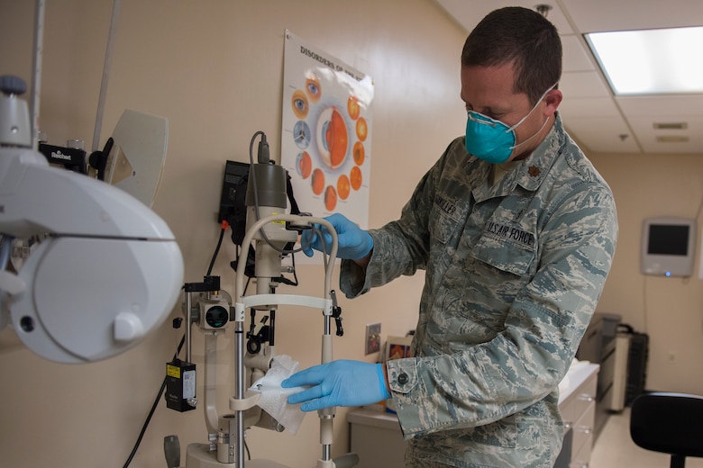 Major Bryan Sixkiller, an optometrist assigned to the 628th Medical Group, Operational Medical Readiness Squadron, cleans equipment at the Optometry Clinic at Joint Base Charleston, S.C., April 7, 2020. Optometry is taking safety measures such as limiting face-to-face time, wearing masks and gloves, frequently washing hands and cleaning medical equipment before and after each examination.