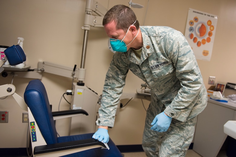 Major Bryan Sixkiller, an optometrist assigned to the 628th Medical Group, Operational Medical Readiness Squadron, cleans equipment at the Optometry Clinic at Joint Base Charleston, S.C., April 7, 2020. Optometry is taking safety measures such as limiting face-to-face time, wearing masks and gloves, frequently washing hands and cleaning medical equipment before and after each examination.