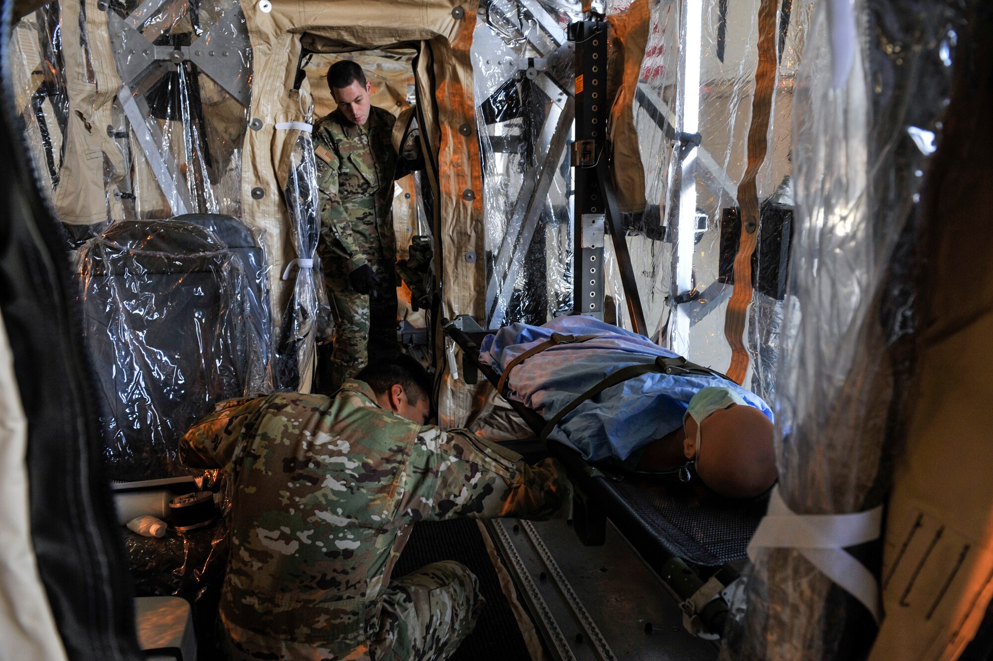 Airmen participating in Transport Isolation System training prepare a mock patient for a training scenario at Joint Base Charleston, S.C., April 4, 2020.