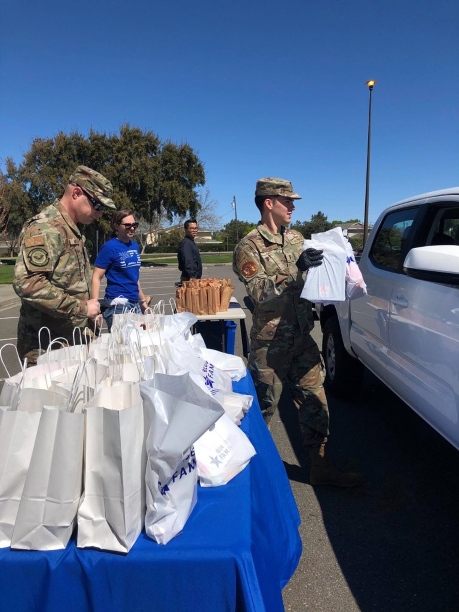Airmen pass out relief kits to Airmen in cars.