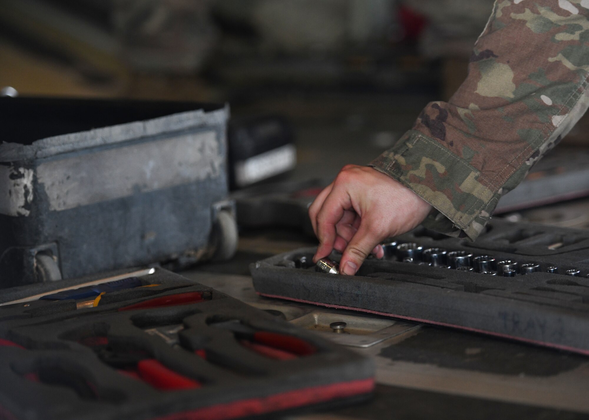 An Airmen puts a small tool away.