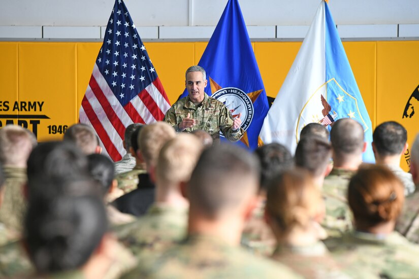 Man in a military uniform speaks to troops.