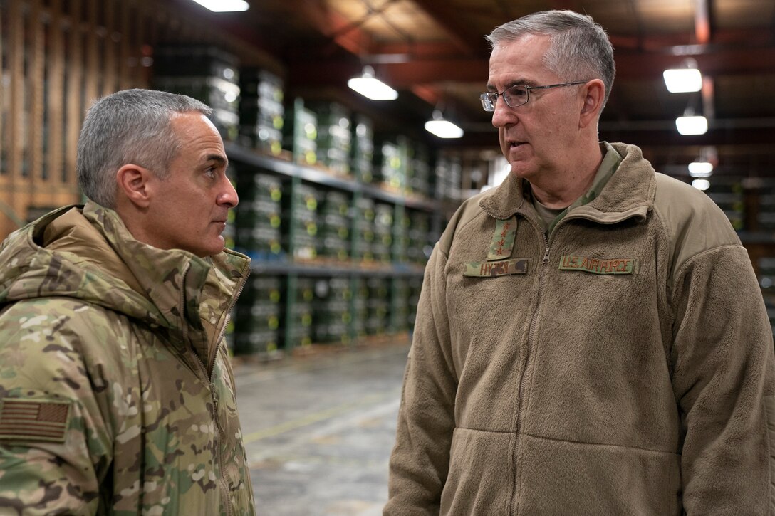 Two men in military uniforms converse.