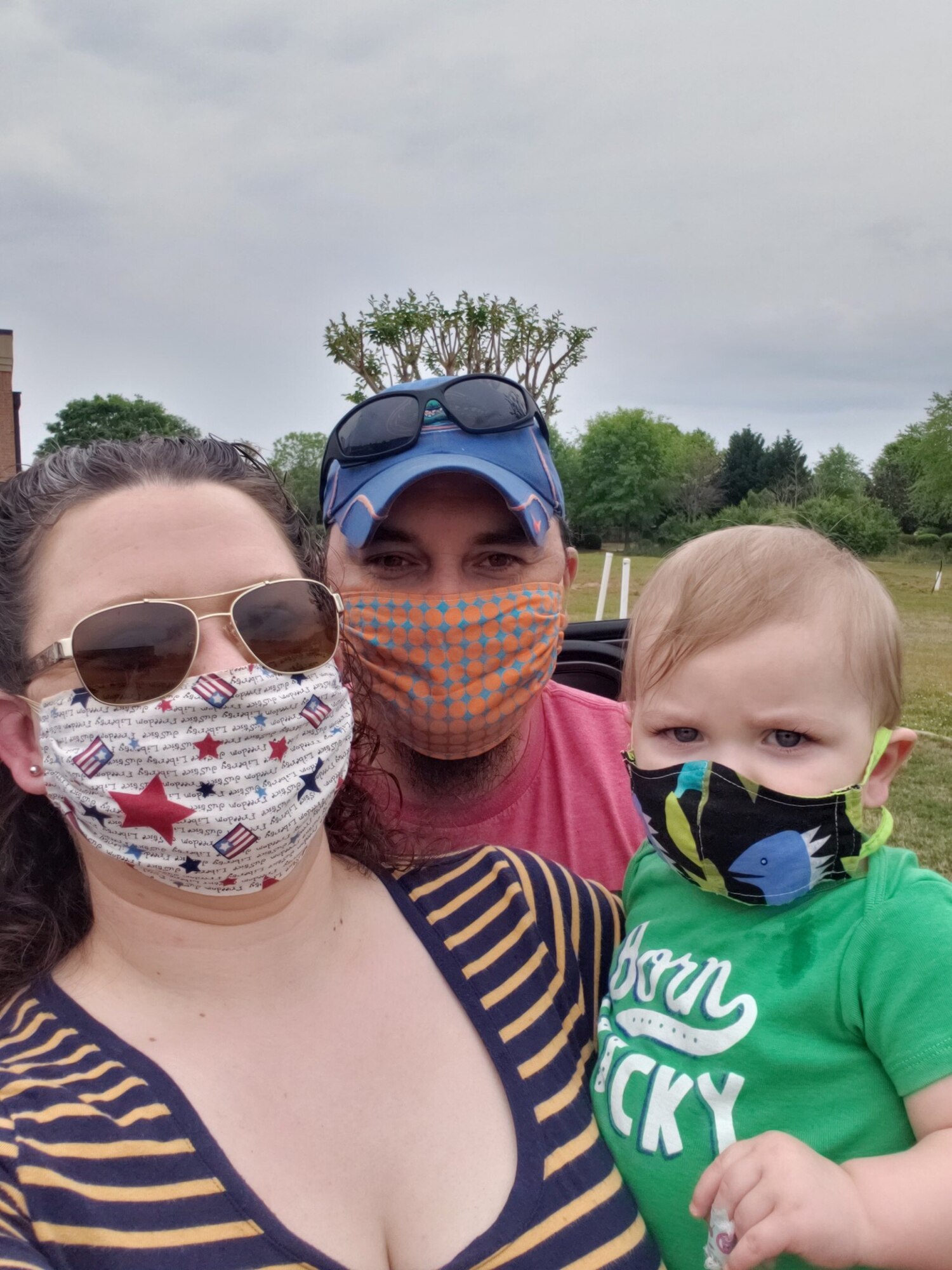 Photo of man, woman  and toddler wearing face masks
