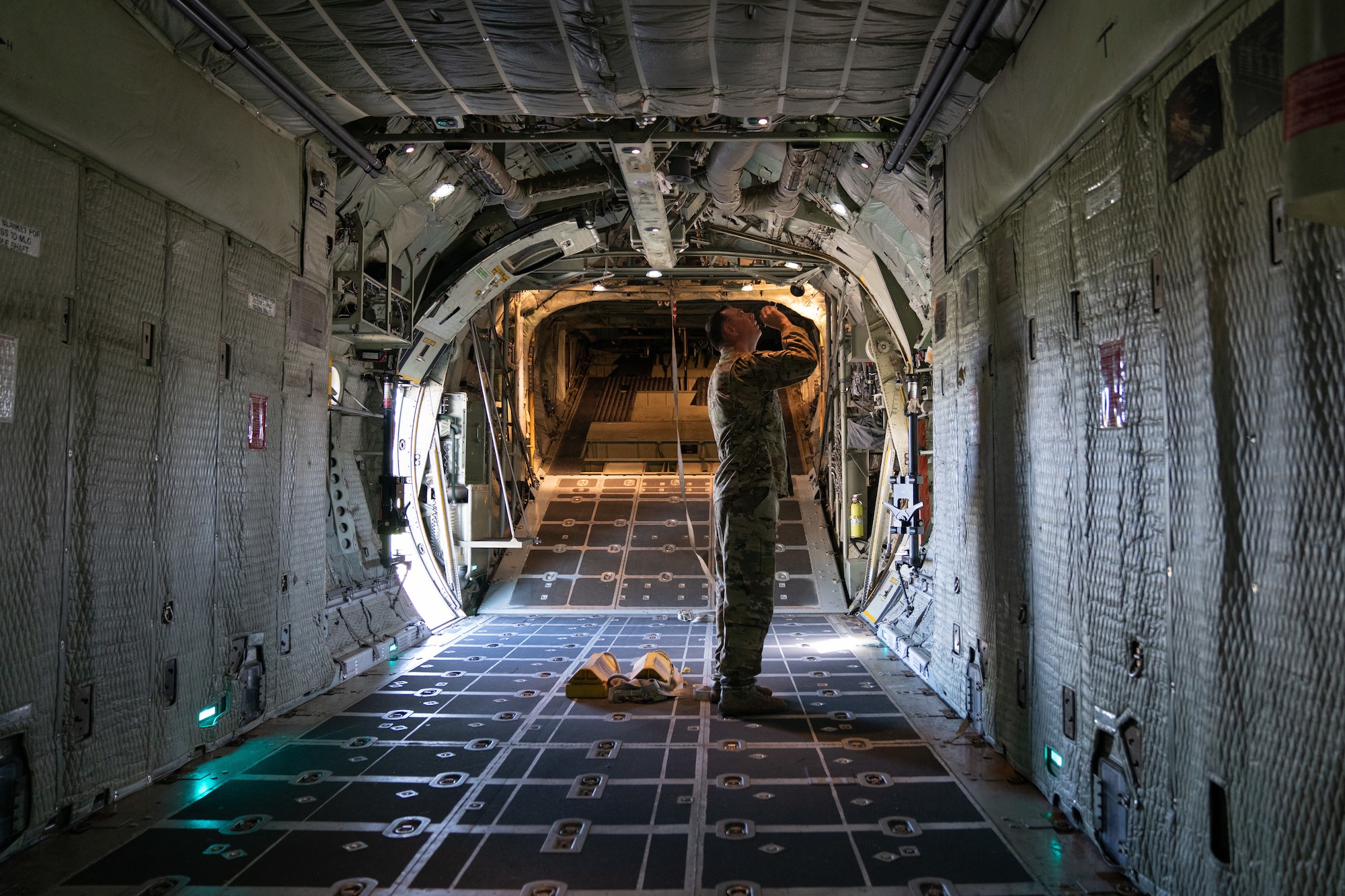 Flight engineer conducts pre-flight checks on a C-130