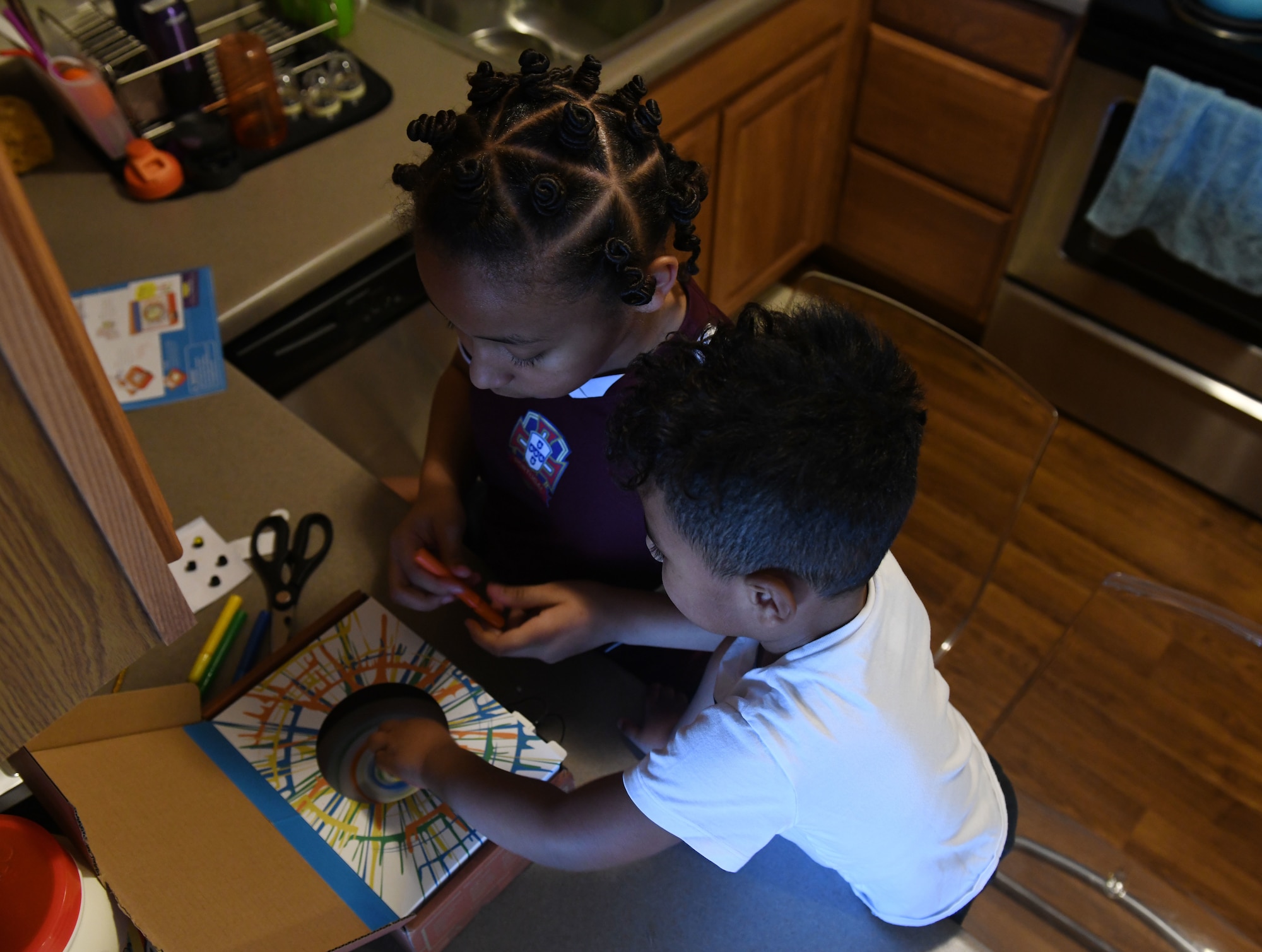 The children of Airman 1st Class Christina Bennett, a 28th Bomb Wing Public Affairs photojournalist, prepare to make a spin art machine during the Covid-19 pandemic at their home in Box Elder, S.D., March 31, 2020. Covid-19 has caused schools and work centers across the United States to close for the unforeseen future. (U.S. Air Force photo by Airman 1st Class Christina Bennett)