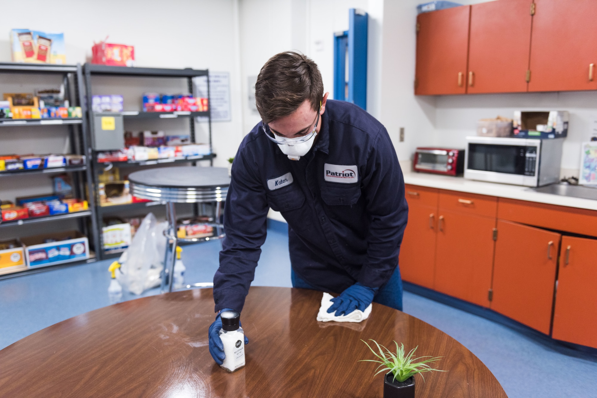 A worker sanitizes a break room inside the Ridley Mission Control Center on Edwards Air Force Base, California, April 10. (Air Force photo by Richard Gonzales)