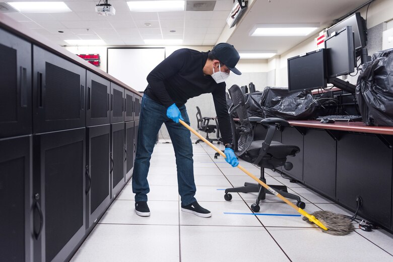A worker sanitizes a Mission Control Room inside the Ridley Mission Control Center on Edwards Air Force Base, California, April 10. (Air Force photo by Richard Gonzales)