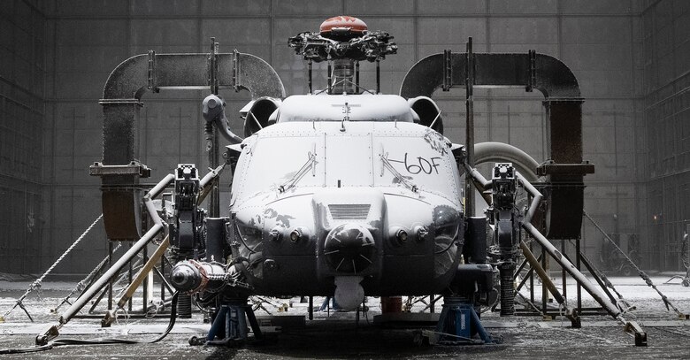 An HH-60W Jolly Green II sits in a frozen chamber