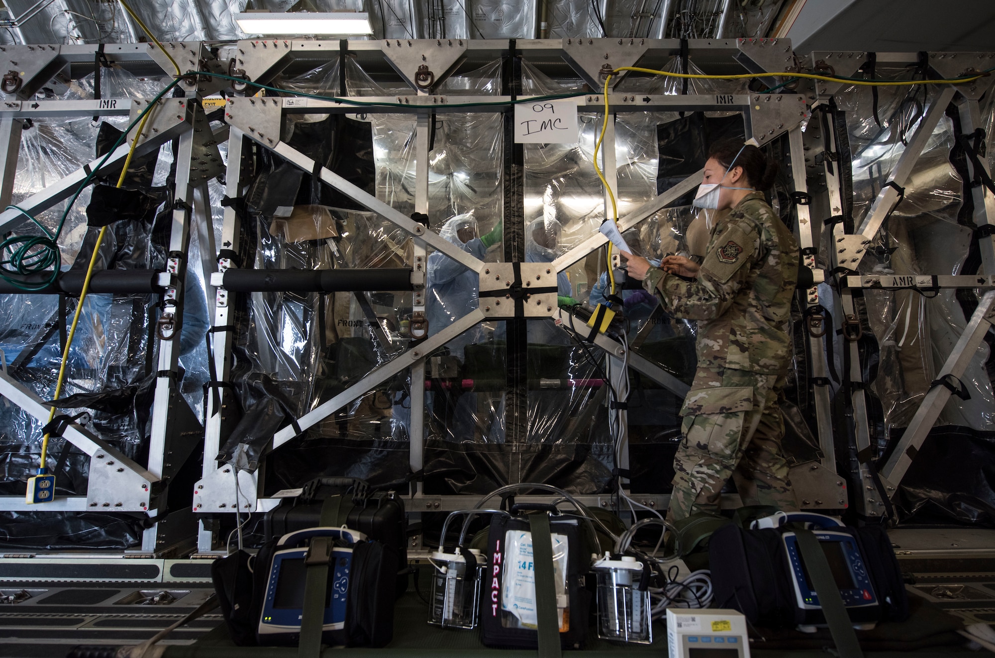 U.S Air Force Capt. Naomi King, 628th Operational Medical Readiness Squadron infectious disease team lead, reviews COVID-19 cleaning procedures with Airmen in the Transport Isolation System at Joint Base Charleston, South Carolina, April 5, 2020. The TIS is an infectious disease containment unit designed to minimize risk to aircrew and medical attendants, while allowing in-flight medical care for patients affected by contagions like COVID-19. MEDCREW, a combination of Aeromedical Evacuation flight nurses and technicians, Critical Care Air Transport teams, Infectious Disease specialists, and TIS support team members, participated in multi-day training at Joint Base Charleston to focus on patient movement using the TIS. The training involved learning how to don and doff personal protective equipment specific to COVID-19, preparing patients for evacuation, loading and unloading patients from the TIS, and configuring the C-17 Globemaster III for patient movement. (U.S. Air Force photo by Senior Airman Allison Payne)