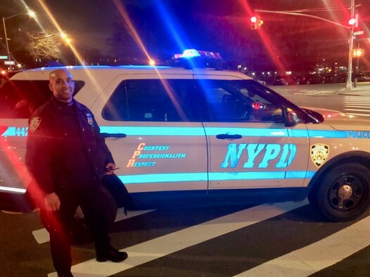 Master Sgt. Andy A. Jean-Pierre with his NYPD patrol vehicle.