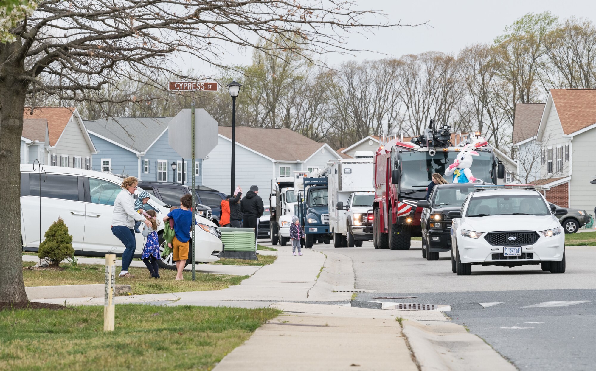 The Easter Bunny waves to housing residents in Eagle Heights housing April 10, 2020, at Dover Air Force Base, Delaware. A small caravan of USO volunteers, 436th Security Forces Squadron and Civil Engineer Squadron vehicles, escorted the Easter Bunny around the housing area in a vehicle driven by Staff Sgt. Tate Booms, 436th LRS vehicle maintenance, accompanied by his wife Cassidy, USO Delaware volunteer. On this Good Friday, the Easter Bunny and residents observed social distancing to mitigate the spread of COVID-19. (U.S. Air Force photo by Roland Balik)