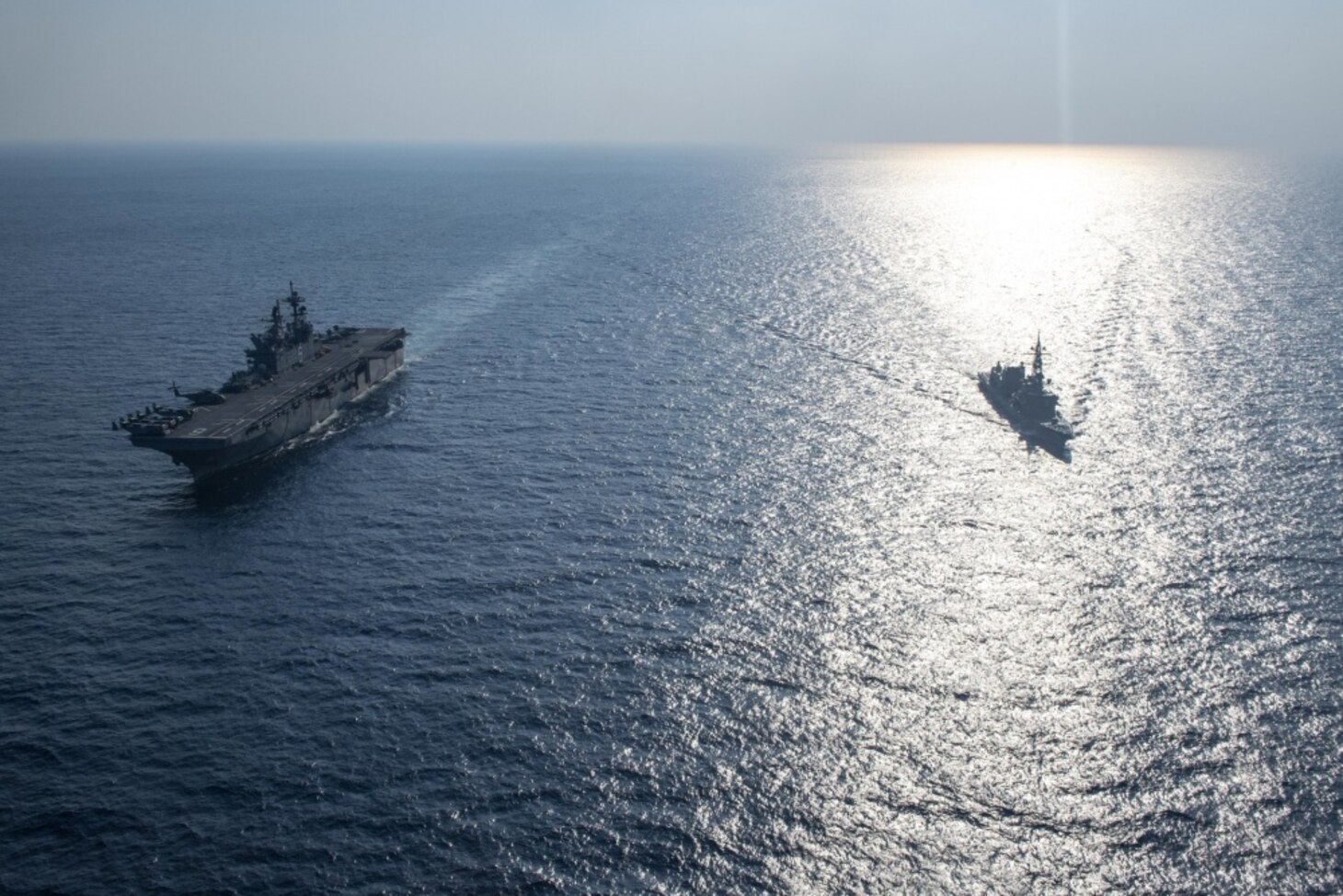 Amphibious assault ship USS America (LHA 6), left, sails with Japanese Maritime Self-Defense Force destroyer JS Akebono (DD 108). America, flagship of the America Expeditionary Strike Group, 31st Marine Expeditionary Unit team, is operating in the U.S. 7th Fleet area of operations to enhance interoperability with allies and partners and serve as a ready response force to defend peace and stability in the Indo-Pacific region.