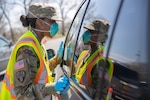 Spc. Gilliam-Gray Shawnese with the 101st Expeditionary Signal Battalion, 369th Sustainment Brigade, New York Army National Guard, gives instructions to people in their vehicle at the COVID-19 Mobile Testing Center in Glenn Island Park, New Rochelle, Apr. 8, 2020. The New York National Guard continues support at seven drive-thru testing sites.