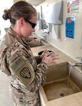 Maj. Jean Kratzer of Task Force Spartan washes her hands at the entrance of a dining facility in the U.S. Central Command area of responsibility. To help prevent the spread of COVID-19, the Centers for Disease Control and Prevention recommends washing your hands often with soap and water for at least 20 seconds. The CDC also recommends disinfecting frequently touched surfaces, avoiding close contact with those who are sick, covering coughs and sneezes with a tissue, cloth, or the inside of your elbow and observing social distancing.