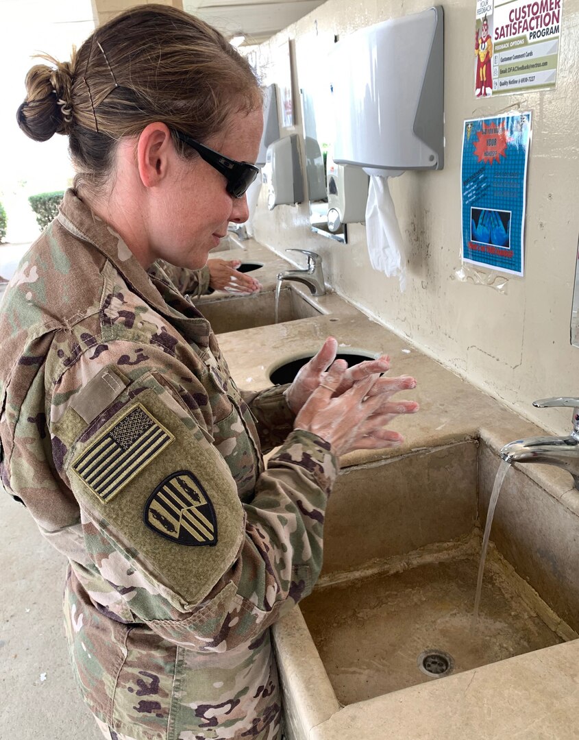 Maj. Jean Kratzer of Task Force Spartan washes her hands at the entrance of a dining facility in the U.S. Central Command area of responsibility. To help prevent the spread of COVID-19, the Centers for Disease Control and Prevention recommends washing your hands often with soap and water for at least 20 seconds. The CDC also recommends disinfecting frequently touched surfaces, avoiding close contact with those who are sick, covering coughs and sneezes with a tissue, cloth, or the inside of your elbow and observing social distancing.