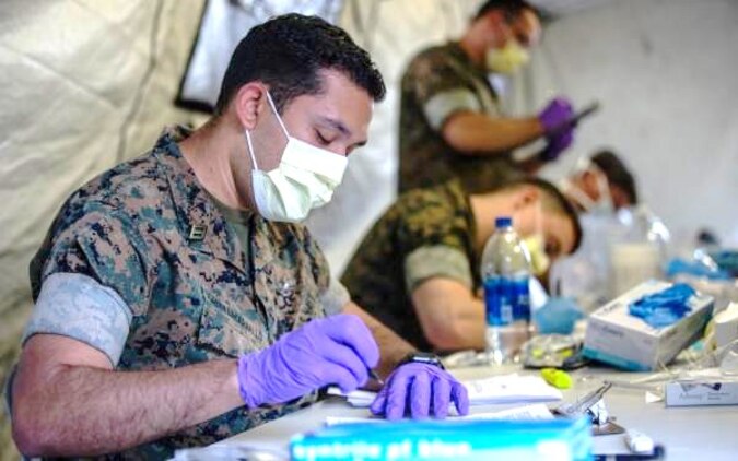 U.S. Navy Sailors with 2nd Medical Battalion, 2nd Marine Logistics Group pre-screen Marines with 2nd Light Armored Reconnaissance Battalion, 2nd Marine Division, on Marine Corps Air Station Cherry Point, North Carolina, March 30, 2020. II Marine Expeditionary Force is following the guidelines set by the Centers for Disease Control and Prevention and the Department of Health and Human Services to take the necessary precautions to protect redeploying service members and mitigate the spread of the coronavirus (COVID-19) outbreak. (U.S. Marine Corps photo by Lance Cpl. Scott Jenkins)
