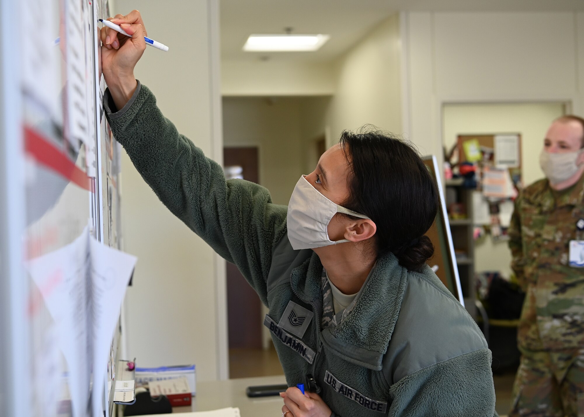 Public Health: Tech. Sgt. Yesenia Benjamin, 66th Medical Squadron noncommissioned officer in charge of the Public Health element, updates a white board at Hanscom Air Force Base, Mass., April 10. Members of Public Health are working to mitigate the spread of coronavirus across the installation. (U.S. Air Force photo by Todd Maki)