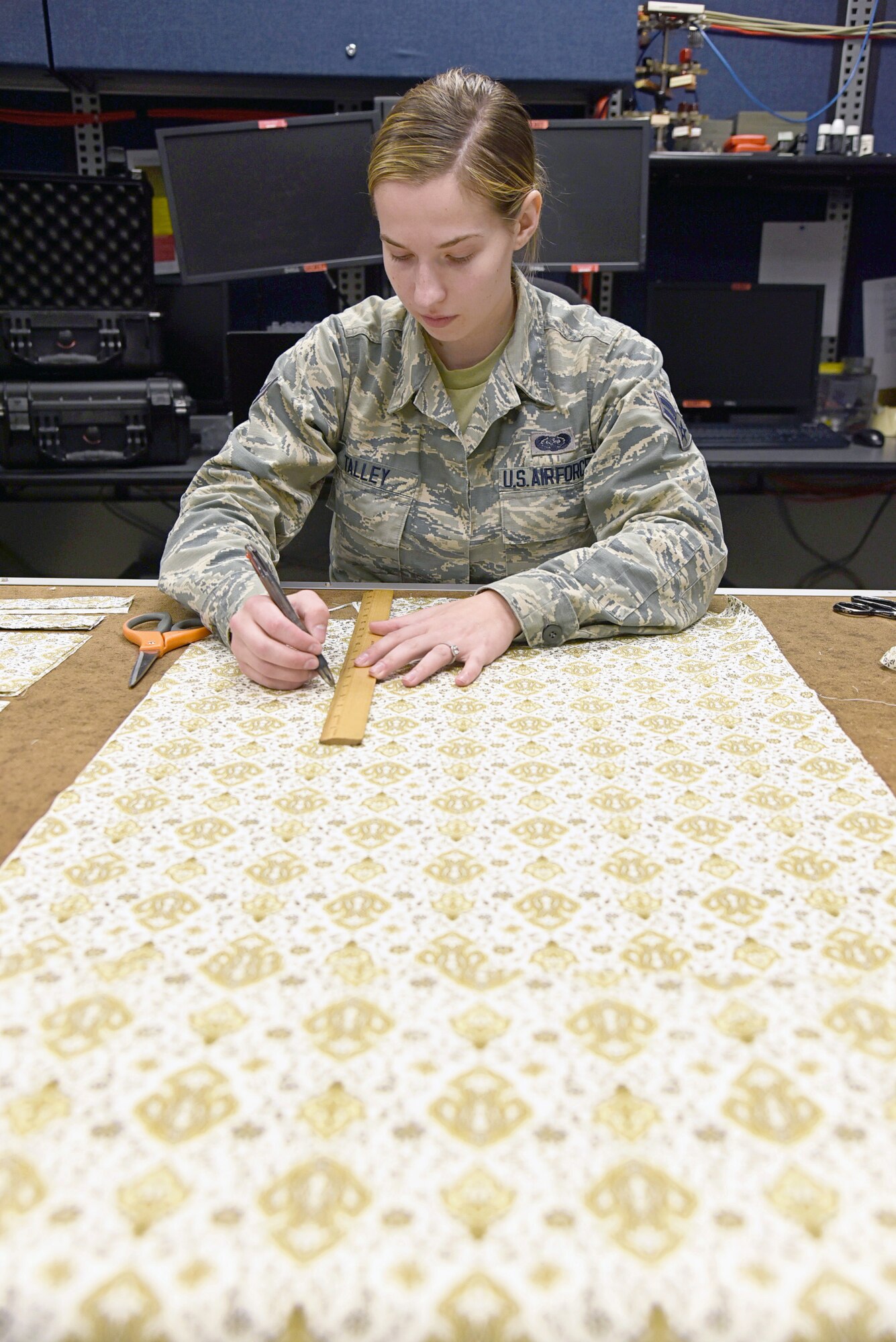 Airman First Class Sarah Talley, with the 552nd Air Control Network Squadron, measures fabric which will be made into face masks to be donated to local hospice and medical facilities around the Tinker community. Fabric and materials were donated by a local store, Sew and Sews, for this project. Over 100 fabric masks have already been made and are ready to donate. (U.S. Air Force photo/Kelly White)