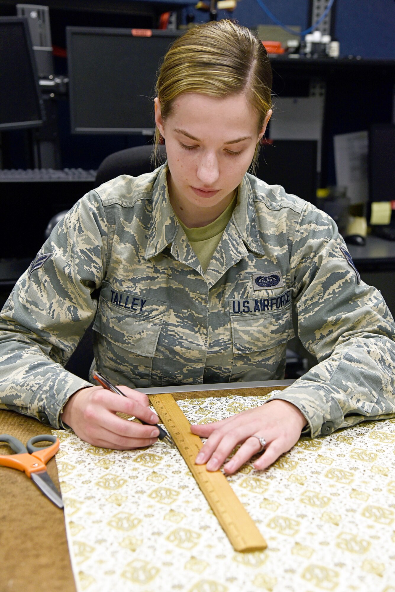 Airman First Class Sarah Talley, with the 552nd Air Control Network Squadron, measures fabric which will be made into face masks to be donated to local hospice and medical facilities around the Tinker community. Fabric and materials were donated by a local store, Sew and Sews, for this project. Over 100 fabric masks have already been made and are ready to donate. (U.S. Air Force photo/Kelly White)