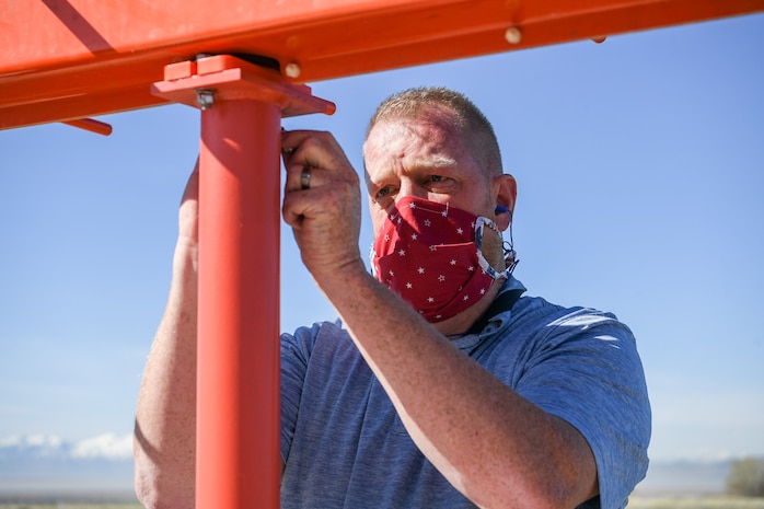A worker tightening a bold on a localizer antenna.