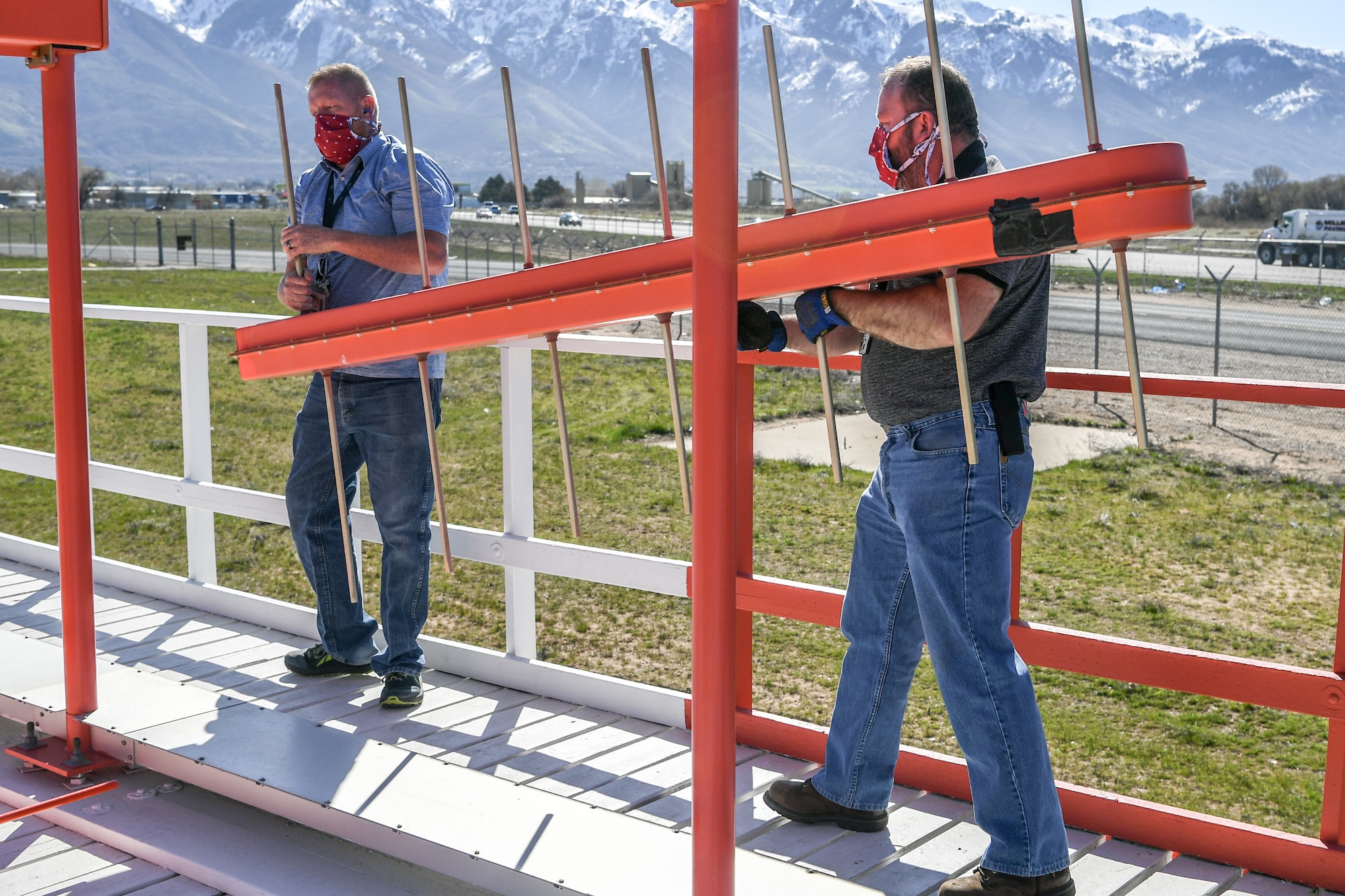 Workers carrying a non-working localizer antenna.