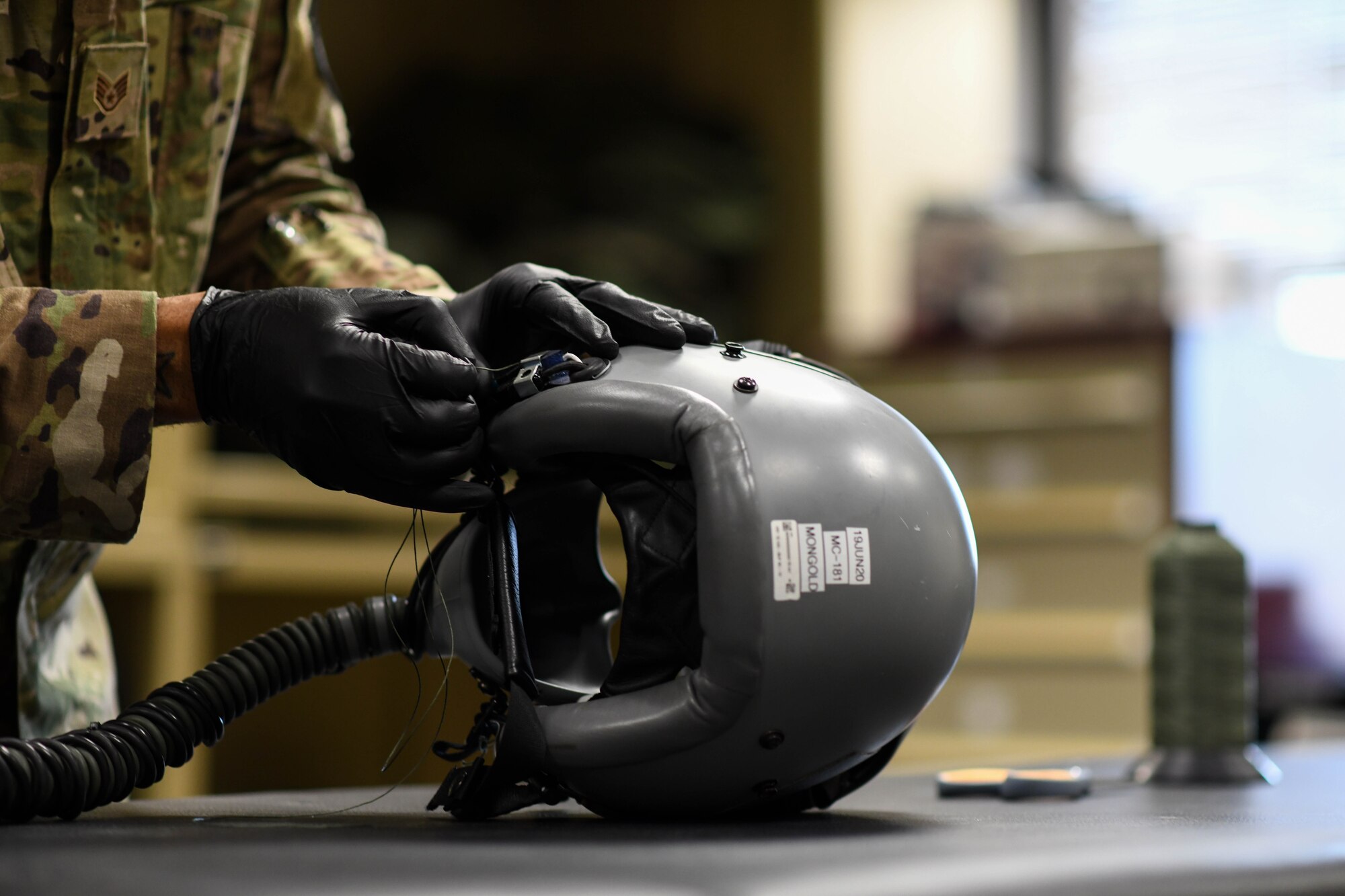 Staff Sgt. Mathew Carr, 22nd Operations Support Squadron aircrew flight equipment technician, re-tacks a cord on a flight helmet March 25, 2020, at McConnell Air Force Base, Kansas. AFE technicians are responsible for ensuring that all flight and safety equipment is operable for aircrew use. (U.S. Air Force photo by Airman 1st Class Nilsa E. Garcia)