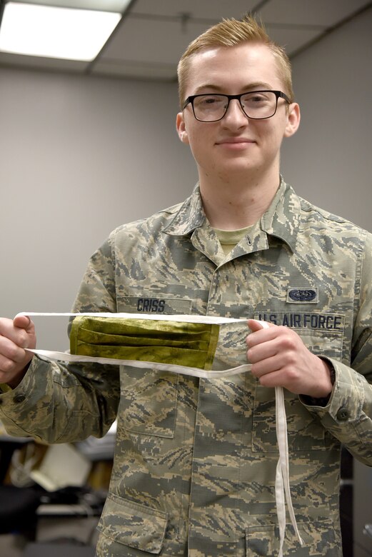 Airman First Class Stephen Criss, with the 552nd Air Control Network Squadron, shows one of the fabric masks that he and other military and spouse volunteers have been working on for the past two weeks. Fabric and materials were donated from a local store for the project. 3-D printed clips to hold plastic face shields are also being produced by volunteers. Both kinds of face protectors are being donated to local hospice and medical facilities in the community outside of Tinker. This project is the volunteers' way to giving back to the community that helps them so much. (U.S. Air Force photo/Kelly White)