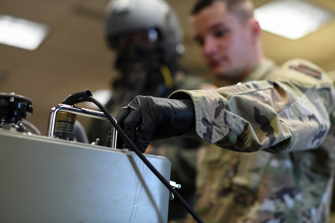 Airman 1st Class Cameron Nixon, 22nd Operations Support Squadron aircrew flight equipment technician, increases the altitude on an oxygen mask test unit, March 25, 2020, at McConnell Air Force Base, Kansas. Oxygen masks are tested for proper seal and oxygen flow at three levels of increasing altitudes. (U.S. Air Force photo by Airman 1st Class Nilsa E. Garcia)