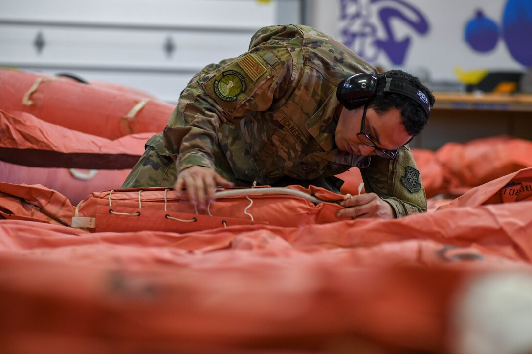 Senior Airman Shawn Tickner, 22nd Operations Support Squadron aircrew flight equipment technician, connects a carbon dioxide cylinder to a life raft March 25, 2020, at McConnell Air Force Base, Kansas. In an emergency situation, the cylinder has the capability to inflate the raft within 60 seconds to keep the aircrew out of harm's way until a rescue team arrives. (U.S. Air Force photo by Airman 1st Class Nilsa E. Garcia)