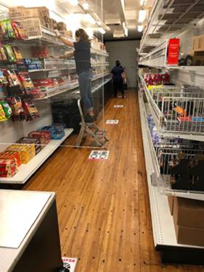 An Army and Air Force Exchange Services (AAFES) associate stocks items on the shelves inside the Mobile Field Exchange trailer