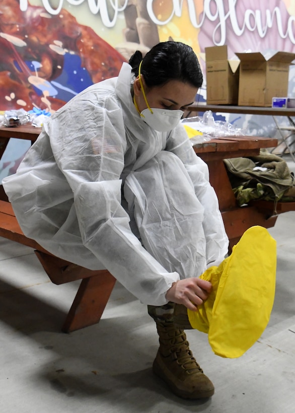 Soldiers from the 26th Maneuver Enhancement Brigade Headquarters and Headquarters Company and the 126th Aviation Battalion put on Personal Protective Equipment before helping administer COVID-19 tests to first responders at a drive thru testing facility, April 9, 2020, on the Big E fairgrounds in West Springfield, Massachusetts. The soldiers worked with other Massachusetts agencies getting individuals tested. The tested individuals should have their results digitally within 48 hours. (U.S. Air National Guard photo by Airman 1st Class Sara Kolinski)