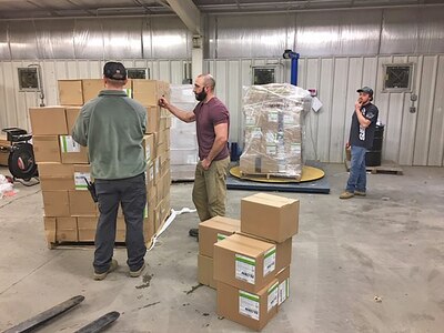 Warehouse personnel prepare boxes of N95 masks for shipment to the Coast Guard.