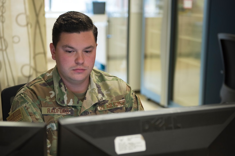 Staff Sgt. Jacob Radford, an allergy and immunizations technician assigned to 628th Health Care Operations Squadron, checks records on a computer at the immunizations office on Joint Base Charleston S.C., April 7, 2020. Immunizations personnel have been taking safety precautions such as screening all patients before treatment, physical distancing, wearing masks and gloves, frequently cleaning work stations, and washing their hands before and after touching a patient.