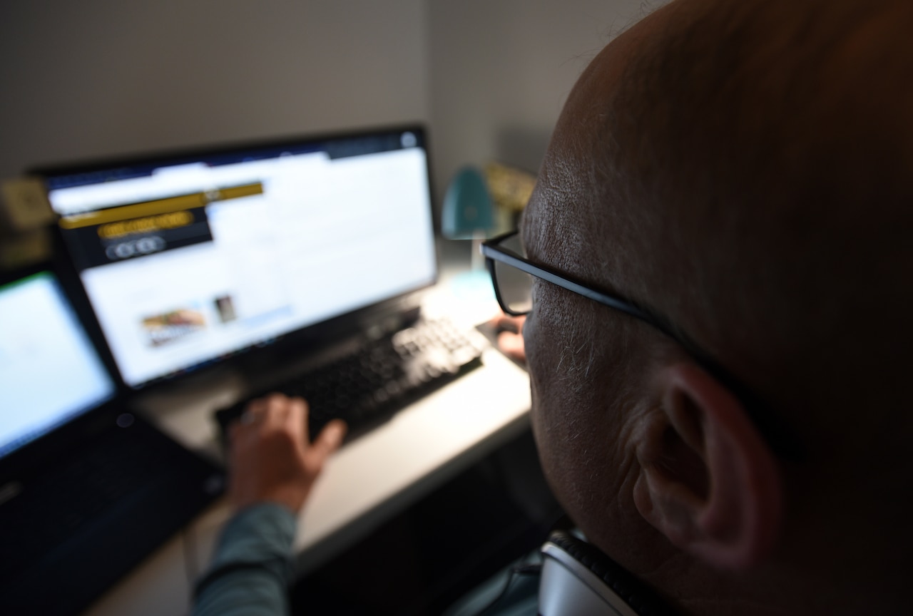 A man uses a computer in his home.